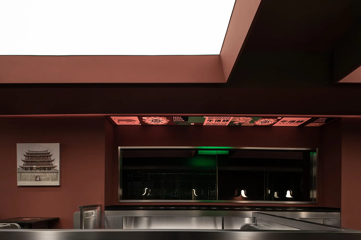 A well-lit restaurant interior with red walls, wooden furniture, and natural light from a large window