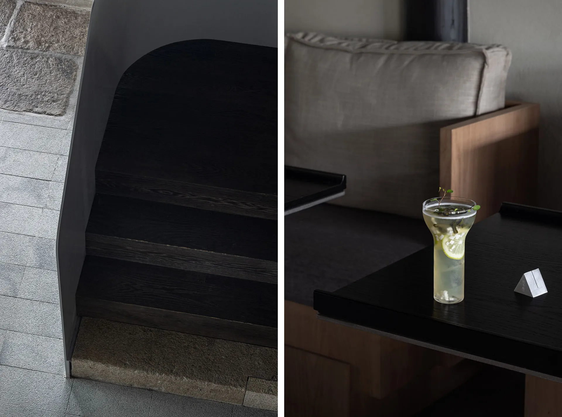 Modern living space with a staircase, a couch, a dining table, and bottles on surfaces