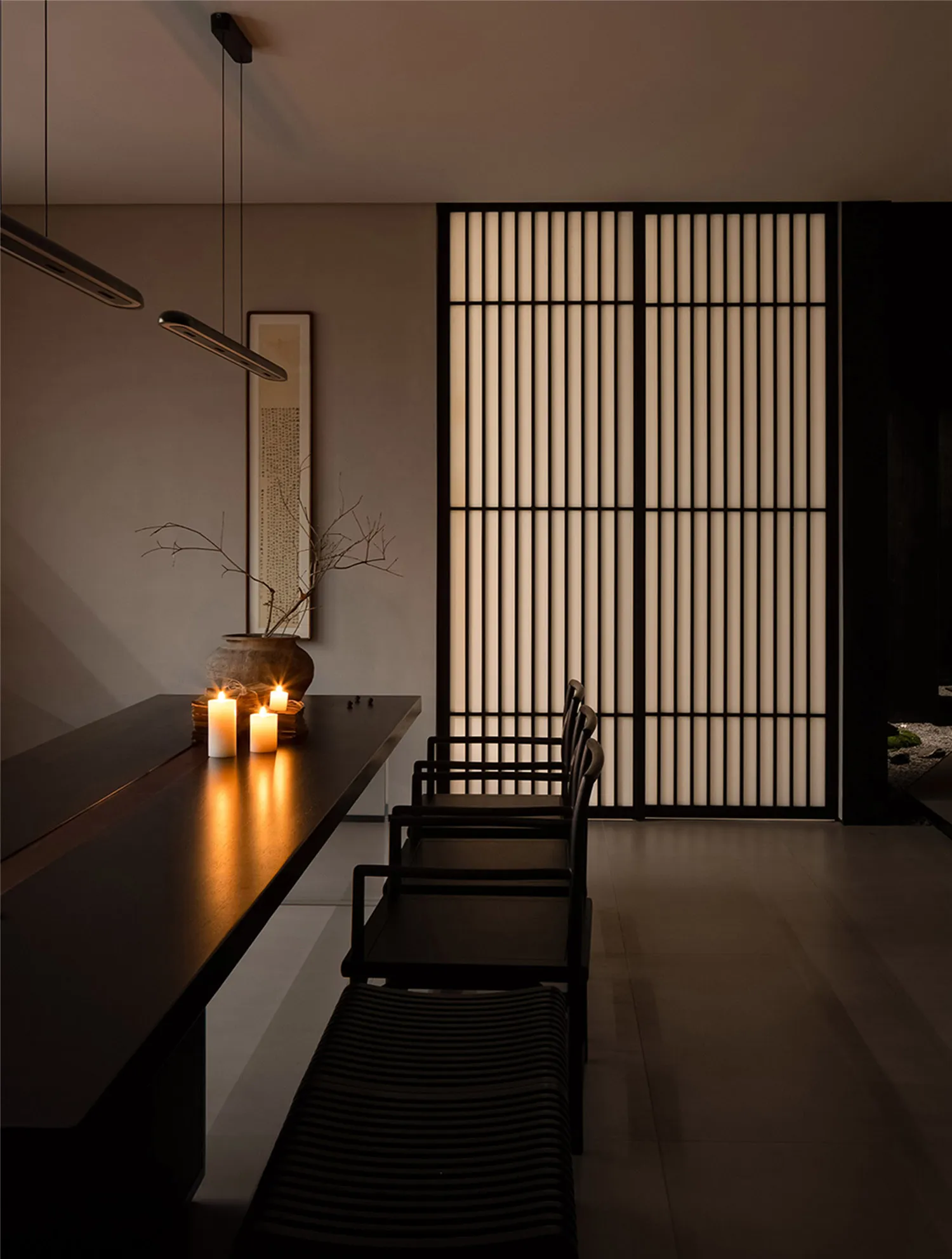 A dining area with a black table and chairs, candles, and vertical blinds, conveying elegance and sophistication