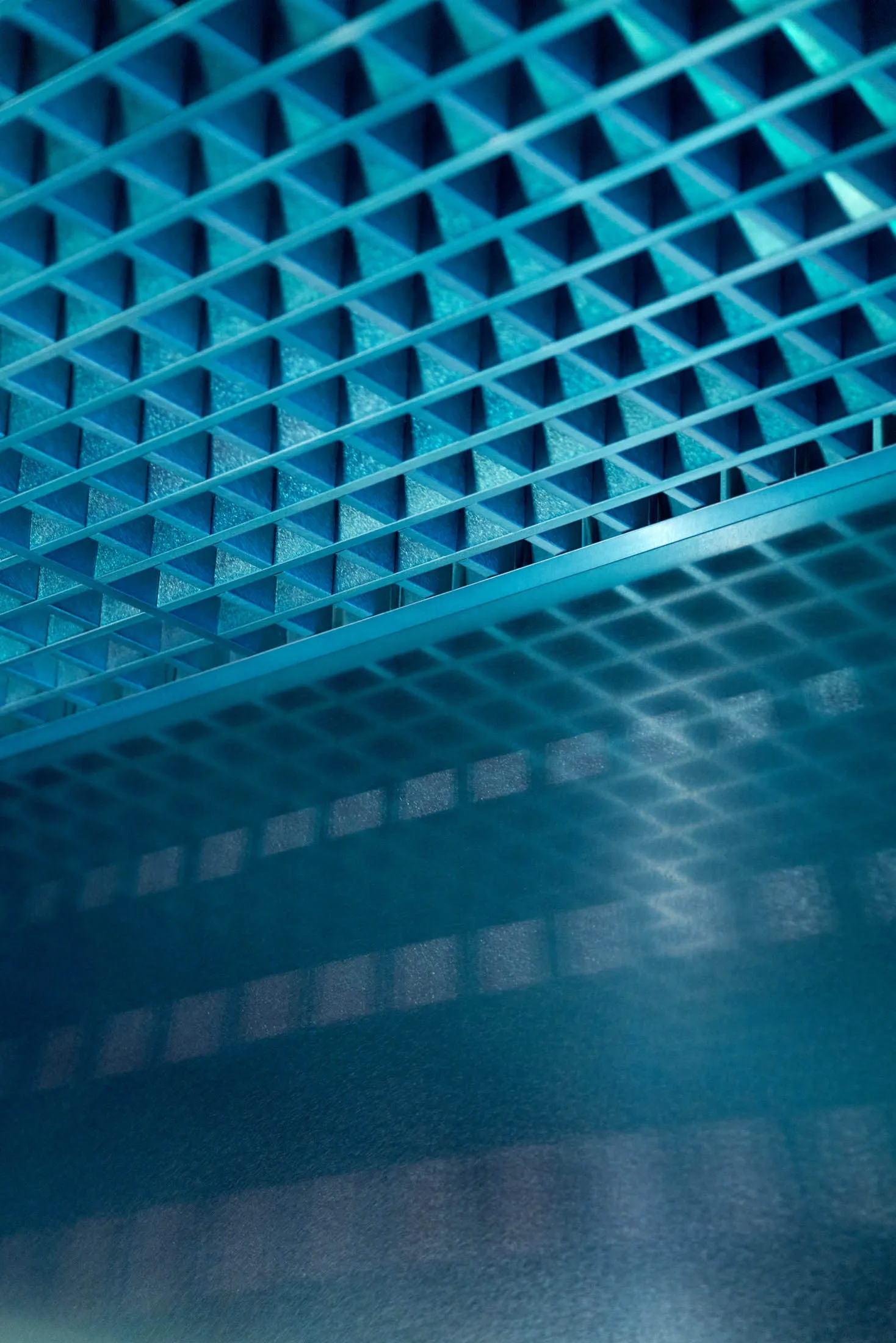 aqua-colored room with a blue tiled floor featuring a unique pattern of small squares and scattered tiles, creating a bright and inviting atmosphere