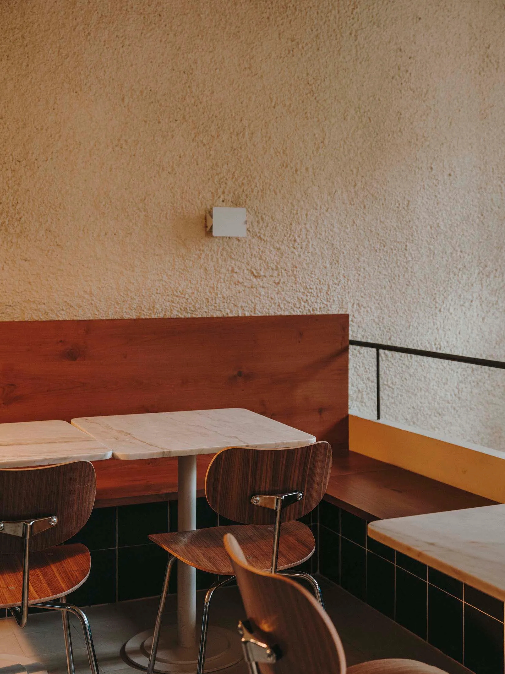 a modern restaurant interior with wooden tables and chairs, giving a warm and inviting atmosphere