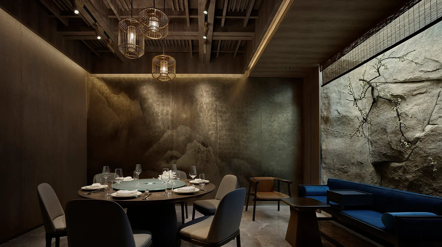 A modern dining area with a round table, chairs, wine glasses, and cups, surrounded by wood and metal elements, with a grayish tint on the walls