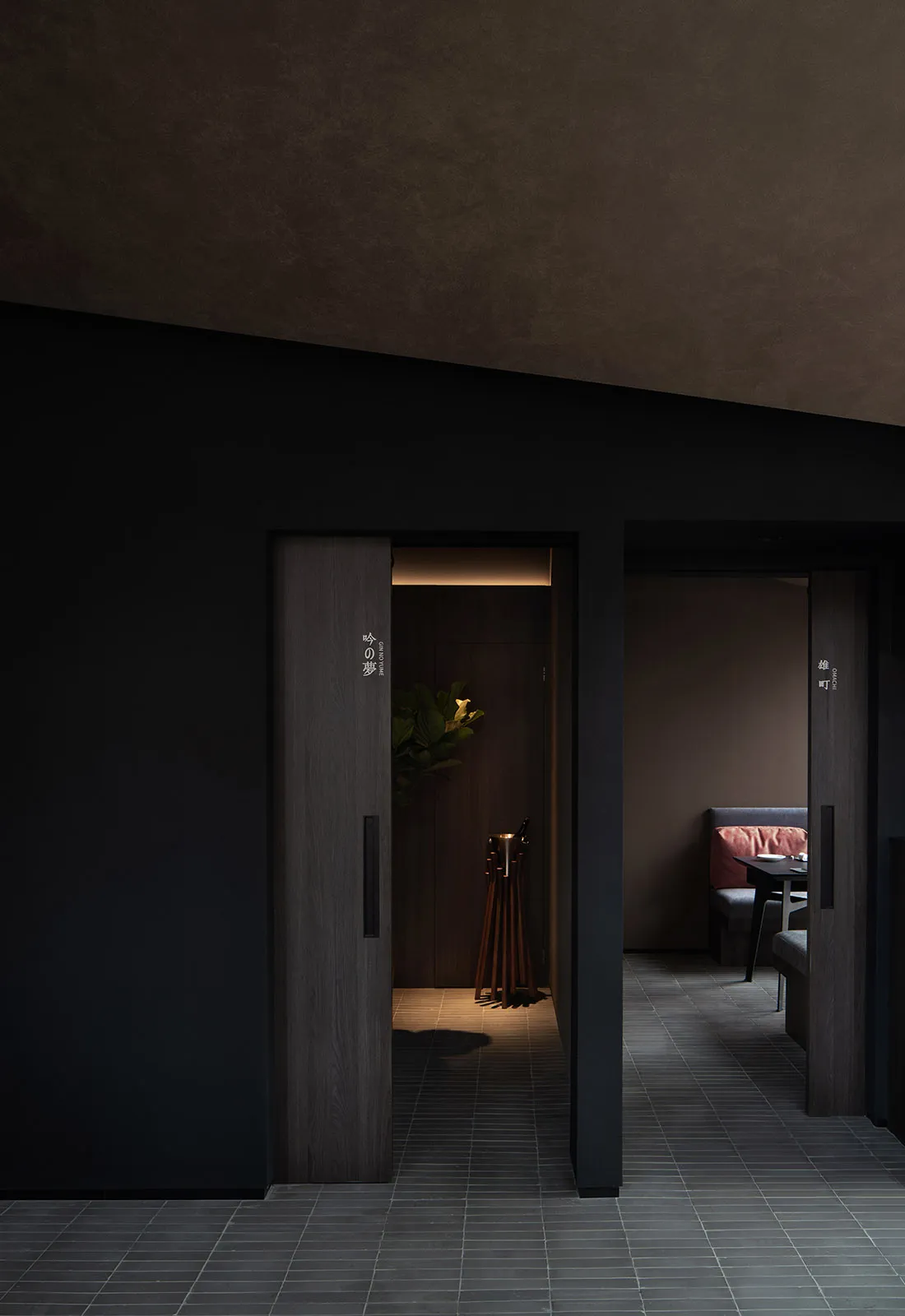 A well-organized hallway with two doors, a potted plant, and signs on the walls