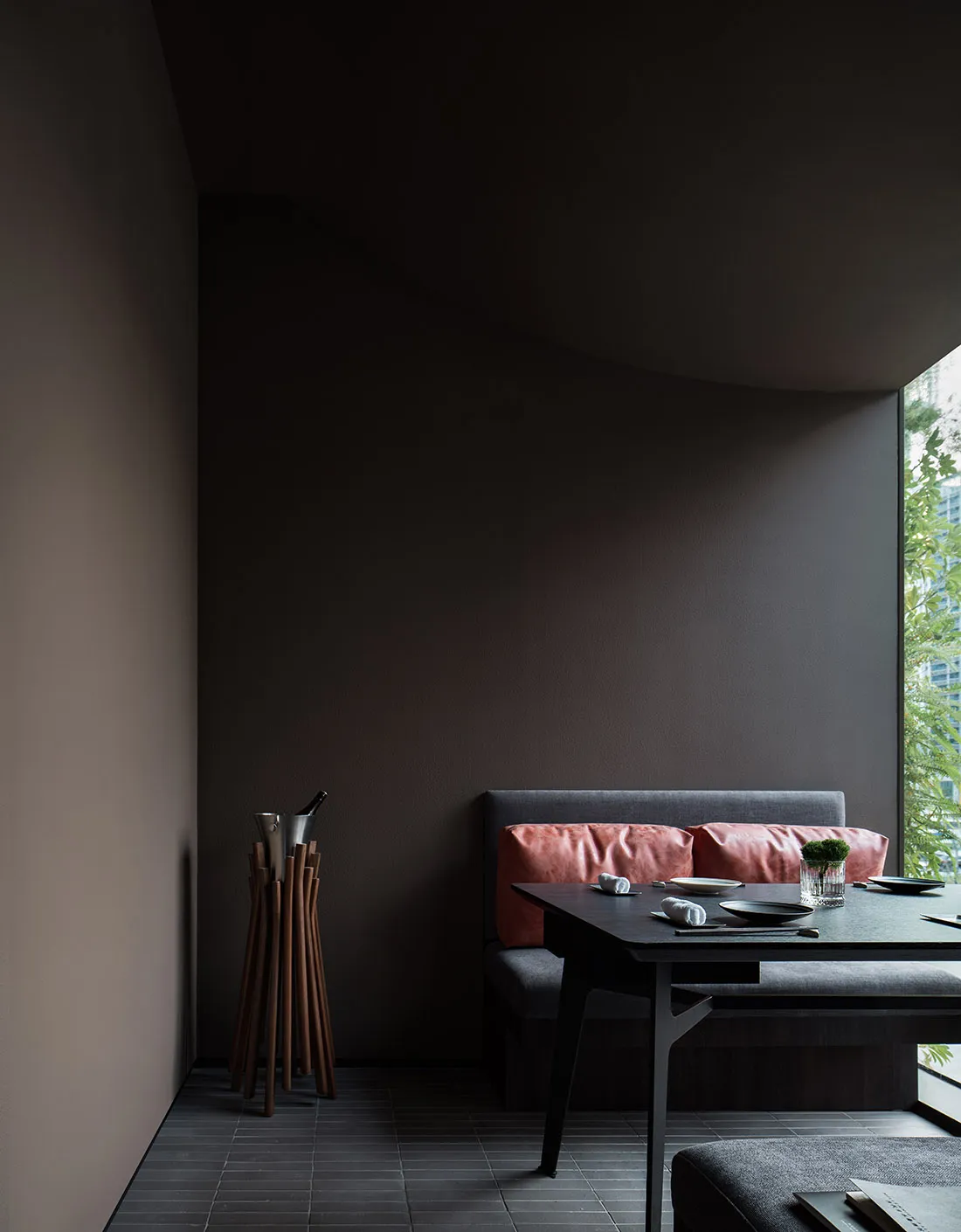 A darkly colored dining room with a table and chairs, two couches, and a vase adding to the cozy ambiance