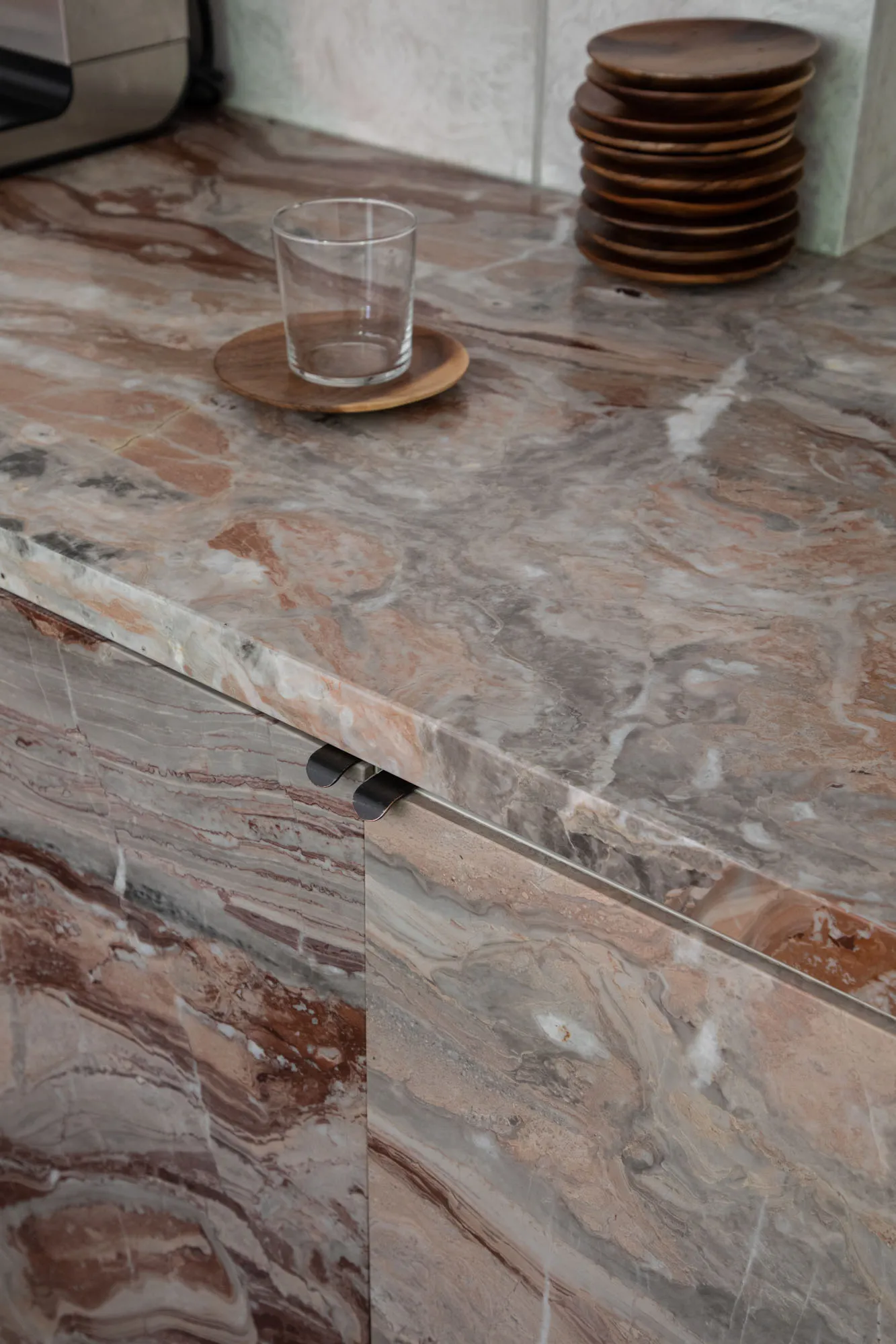 A modern kitchen with a marble countertop, sink, and cup, featuring a luxurious and sophisticated design