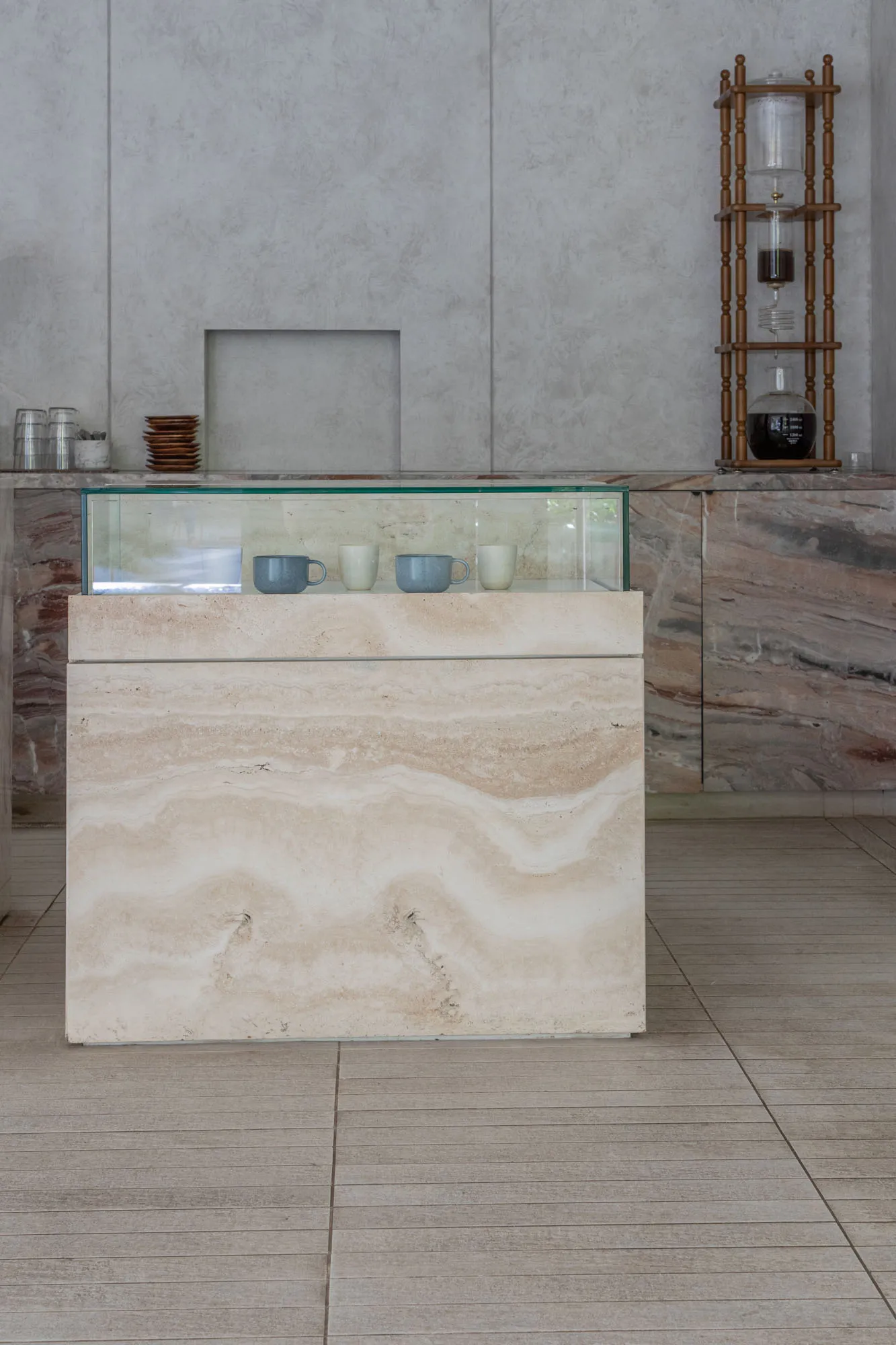 A clean and organized interior design showroom with a marble countertop display, featuring three cups and a luxurious ambiance