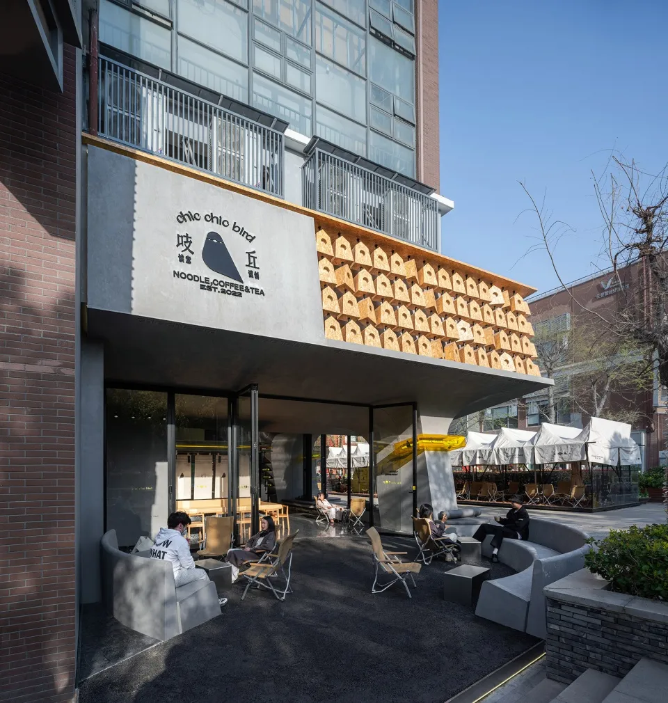An Asian restaurant with a unique wooden roof design, a patio area, and dining tables with umbrellas