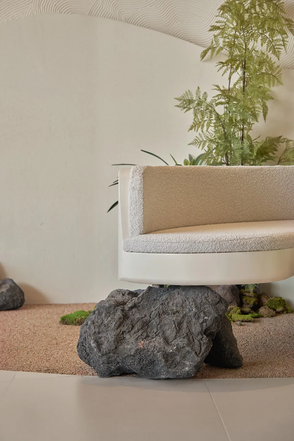A serene indoor space with a concrete bench surrounded by potted plants, creating a calming atmosphere