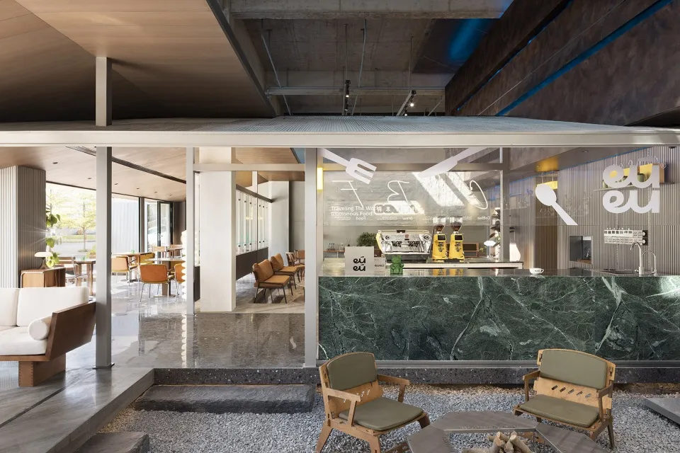 A modern restaurant with a marble countertop bar, dining tables, and comfortable seating for customers