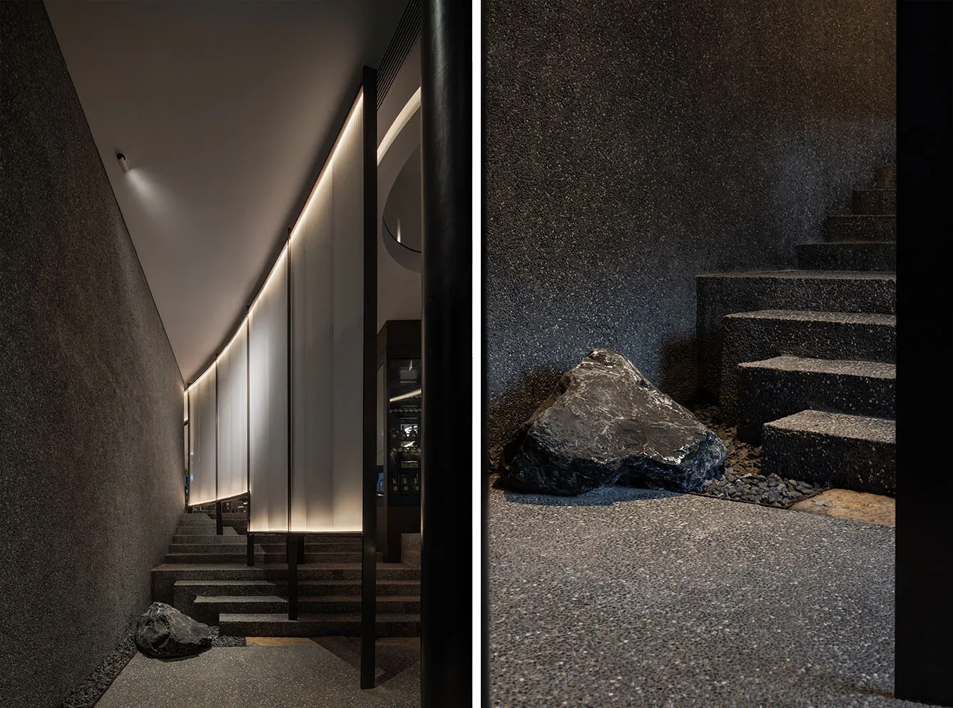 Contemporary building with black stone wall and metal railing, featuring a staircase and sleek design