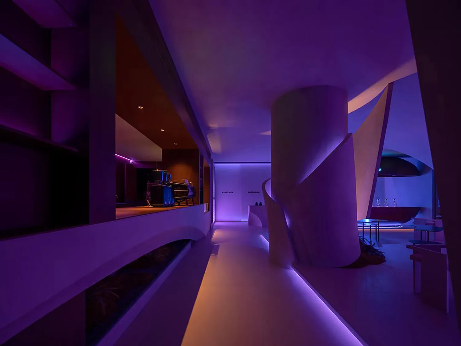 Modern open living space with purple walls, a spiral staircase, two chairs, and a dining table