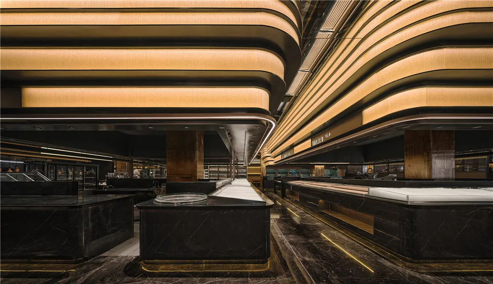 Elegant hotel lobby with a marble countertop, surrounded by seating areas and warm lighting