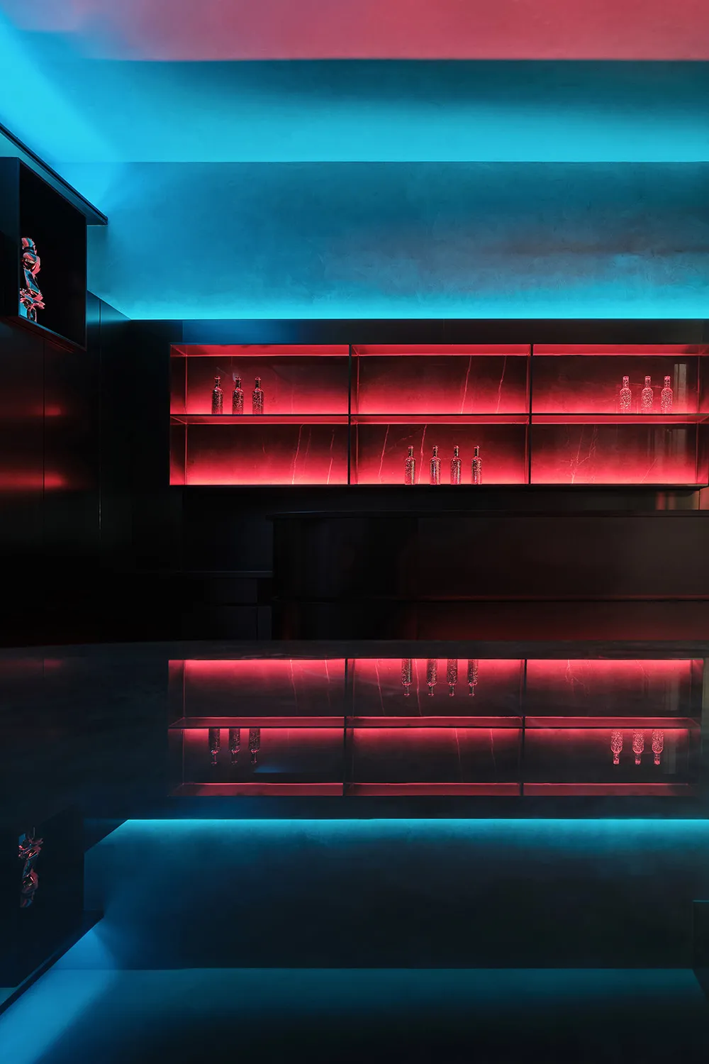 Modern bar area with a black countertop, red glow, and bottles on the counter