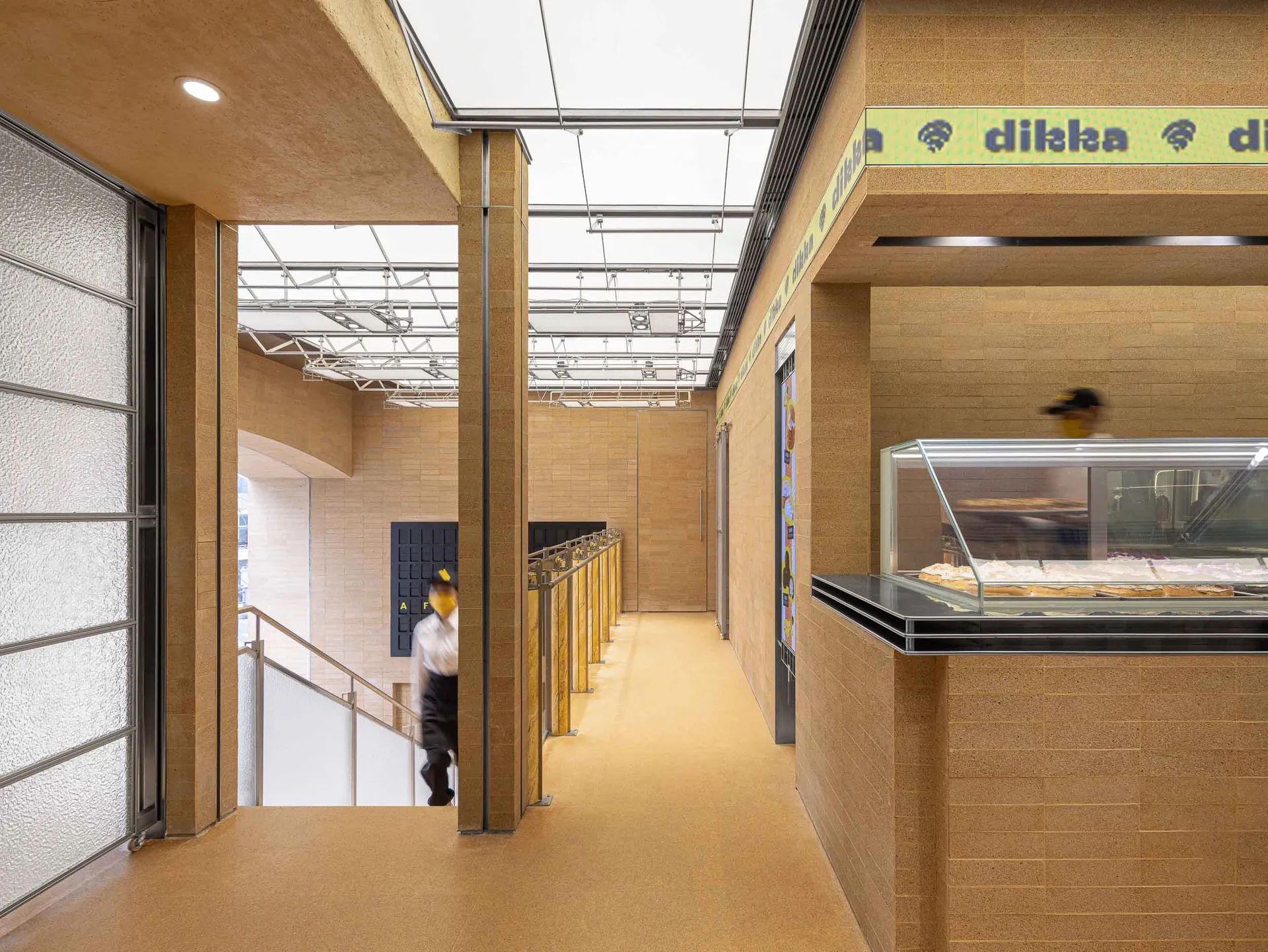 熱鬧的餐廳內部，配有木質地板、餐桌、椅子，並展示披薩，營造出適合社交與用餐的溫馨氛圍