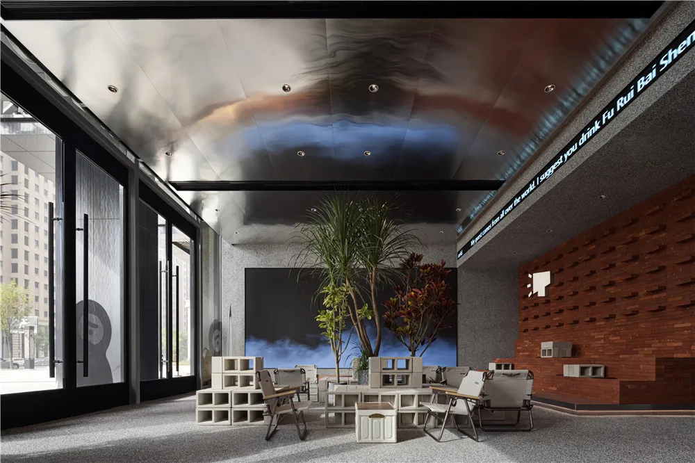 A large room with a dining table and chairs, surrounded by potted plants, creating a comfortable and relaxing atmosphere