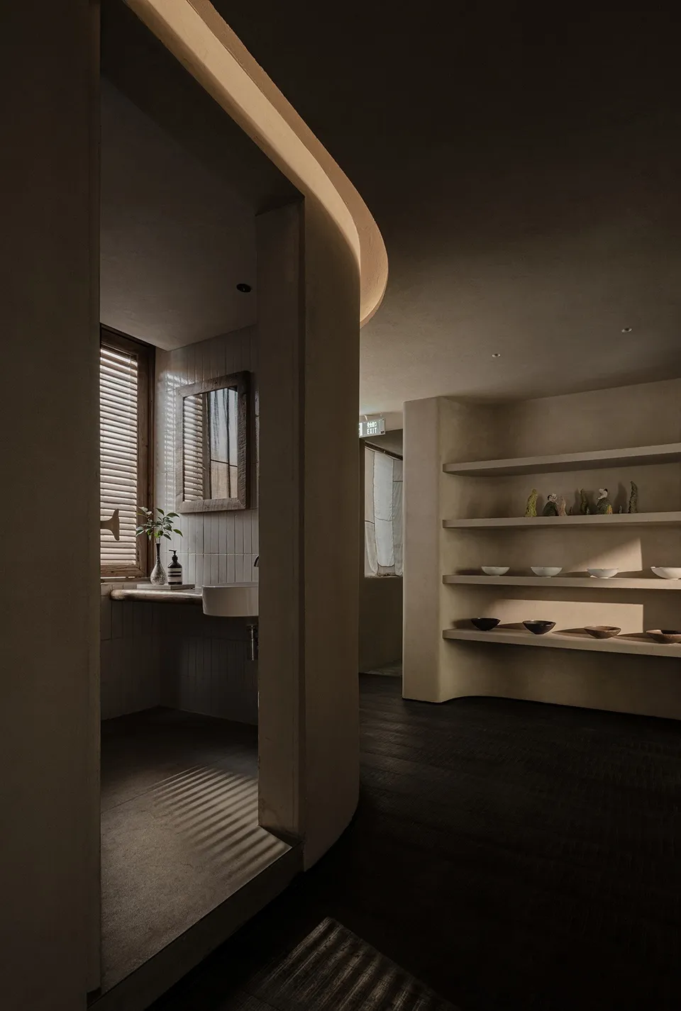 Dimly lit bathroom with tile walls, a sink, a mirror, and decorative vases