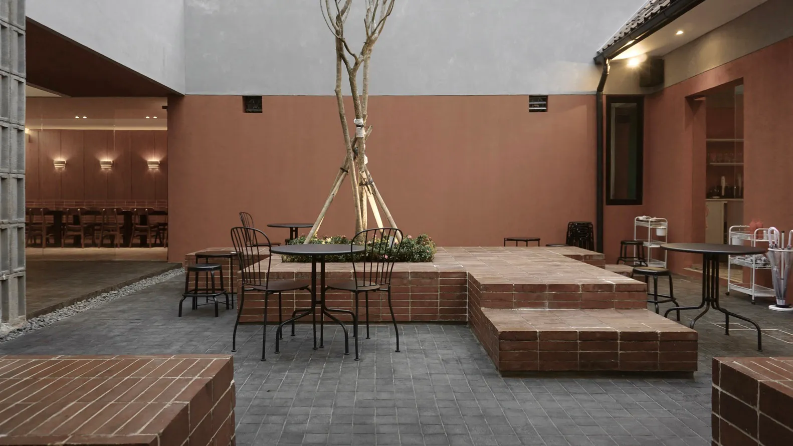 A wooden dining table surrounded by chairs in a cozy outdoor patio with a potted plant and inviting atmosphere