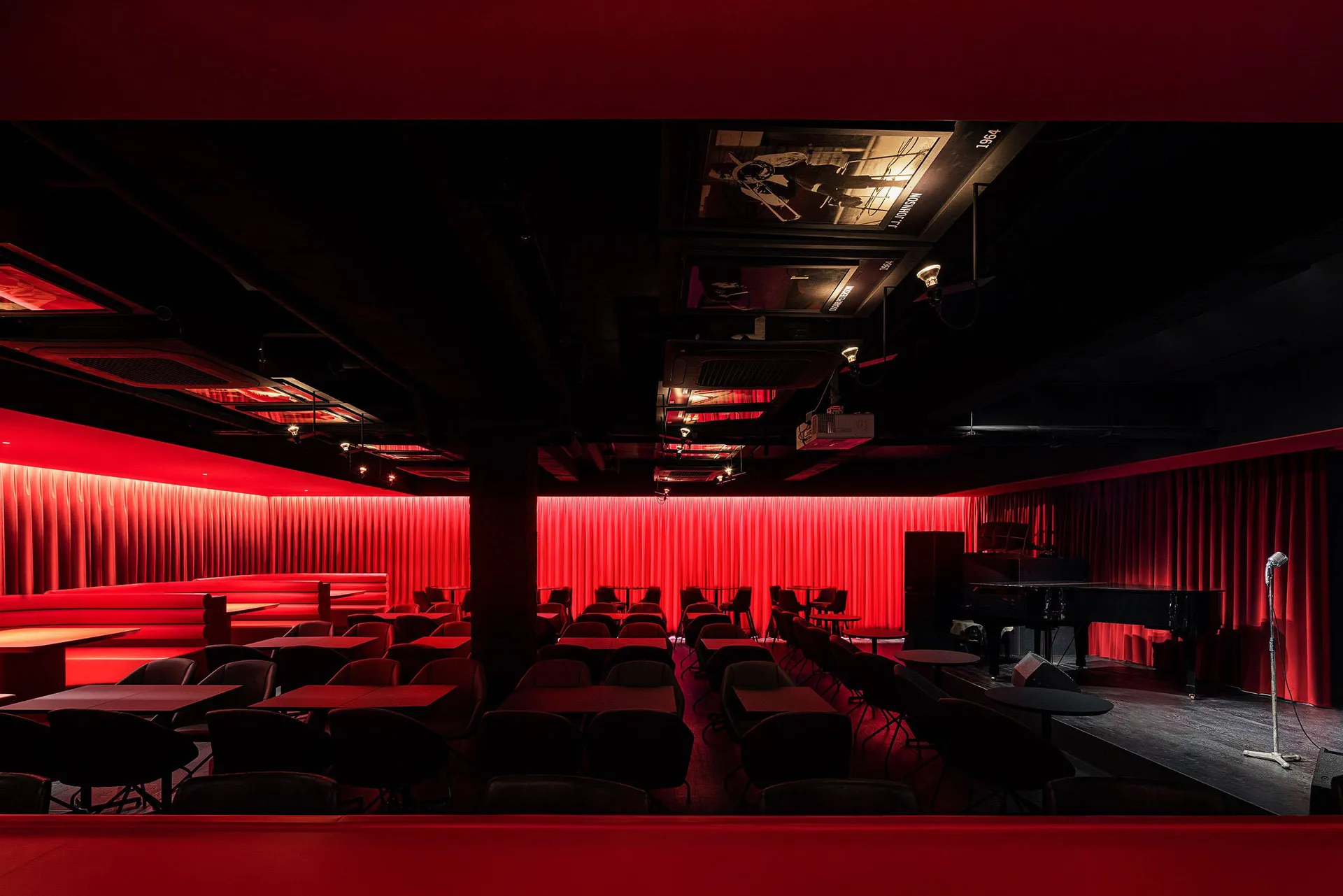 Cozy modern restaurant interior with red walls, black tables, and various chairs, creating a welcoming atmosphere