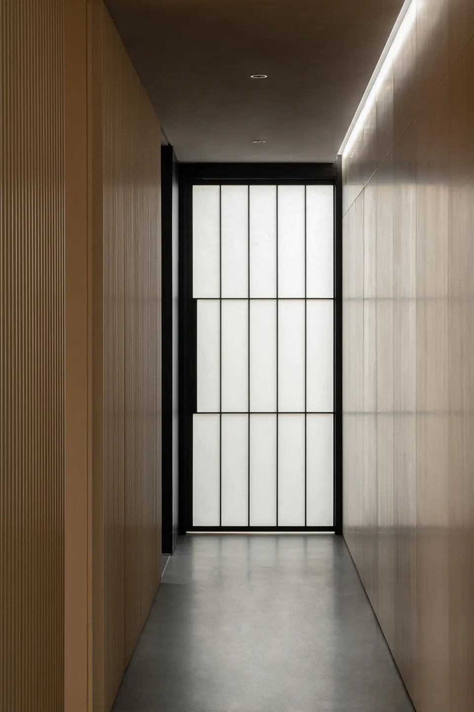 A simple hallway with a black door and glass window, set against a wooden background