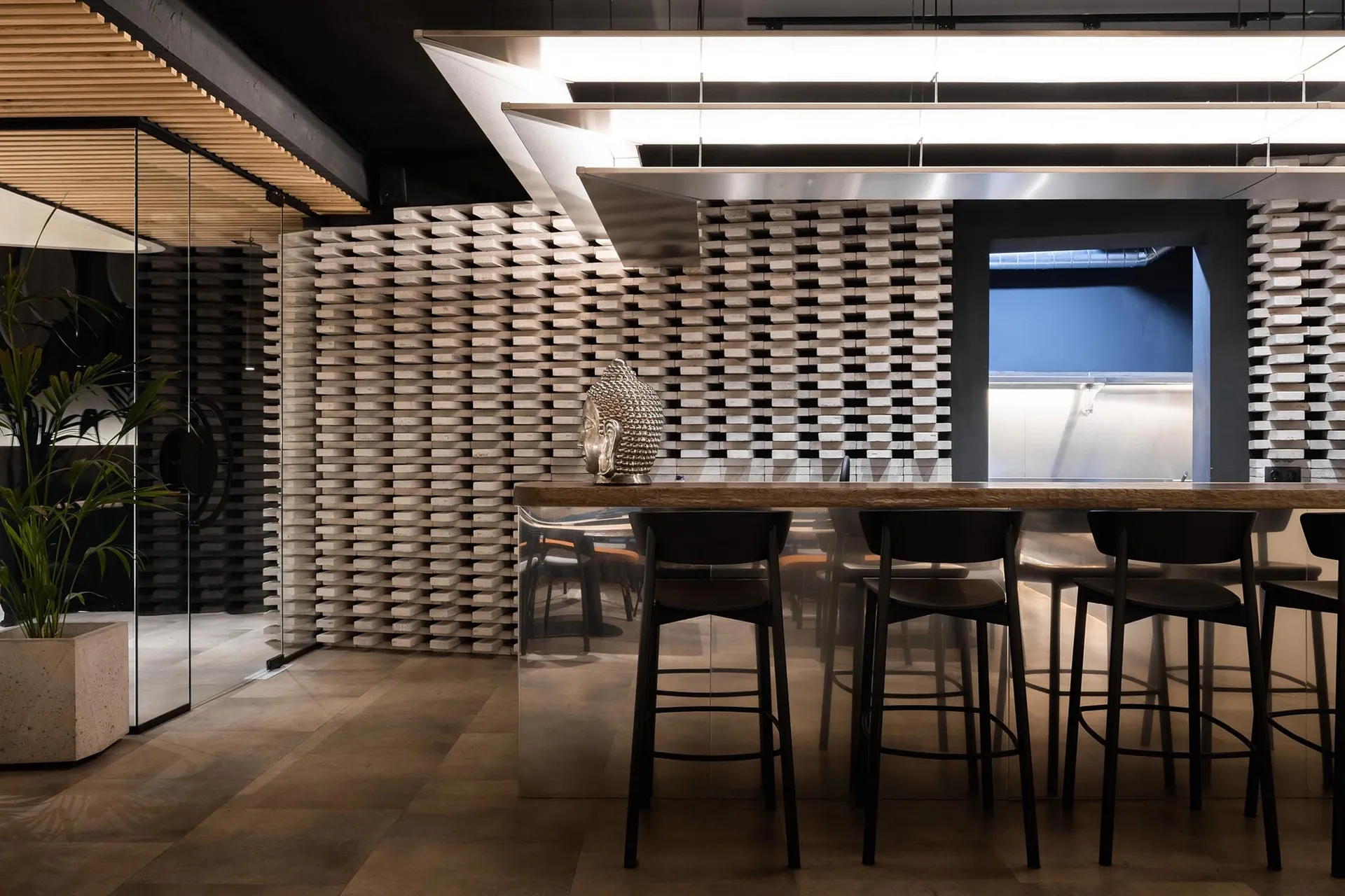 Modern kitchen with a center island bar, dining table, and four chairs, featuring a vase on the table and a warm and inviting atmosphere