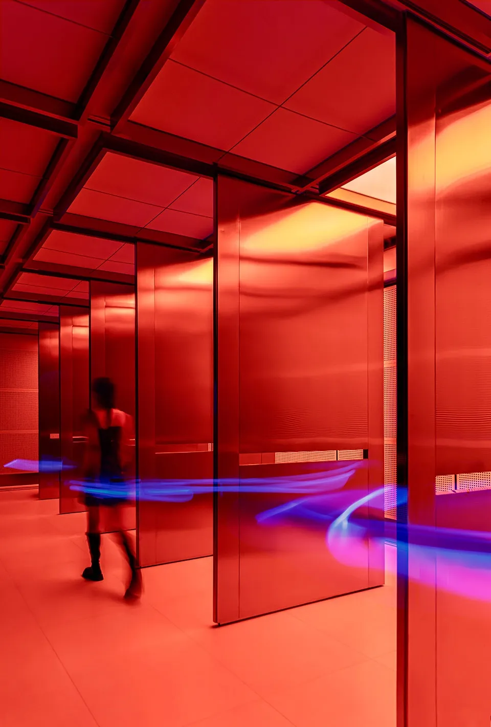 A bright and inviting hallway with red walls and doors, featuring two people in a well-lit space