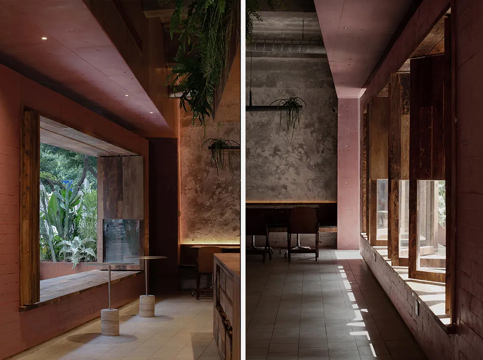 A modern restaurant interior with a warm atmosphere, featuring a combination of wood and concrete elements, dining tables, and potted plants