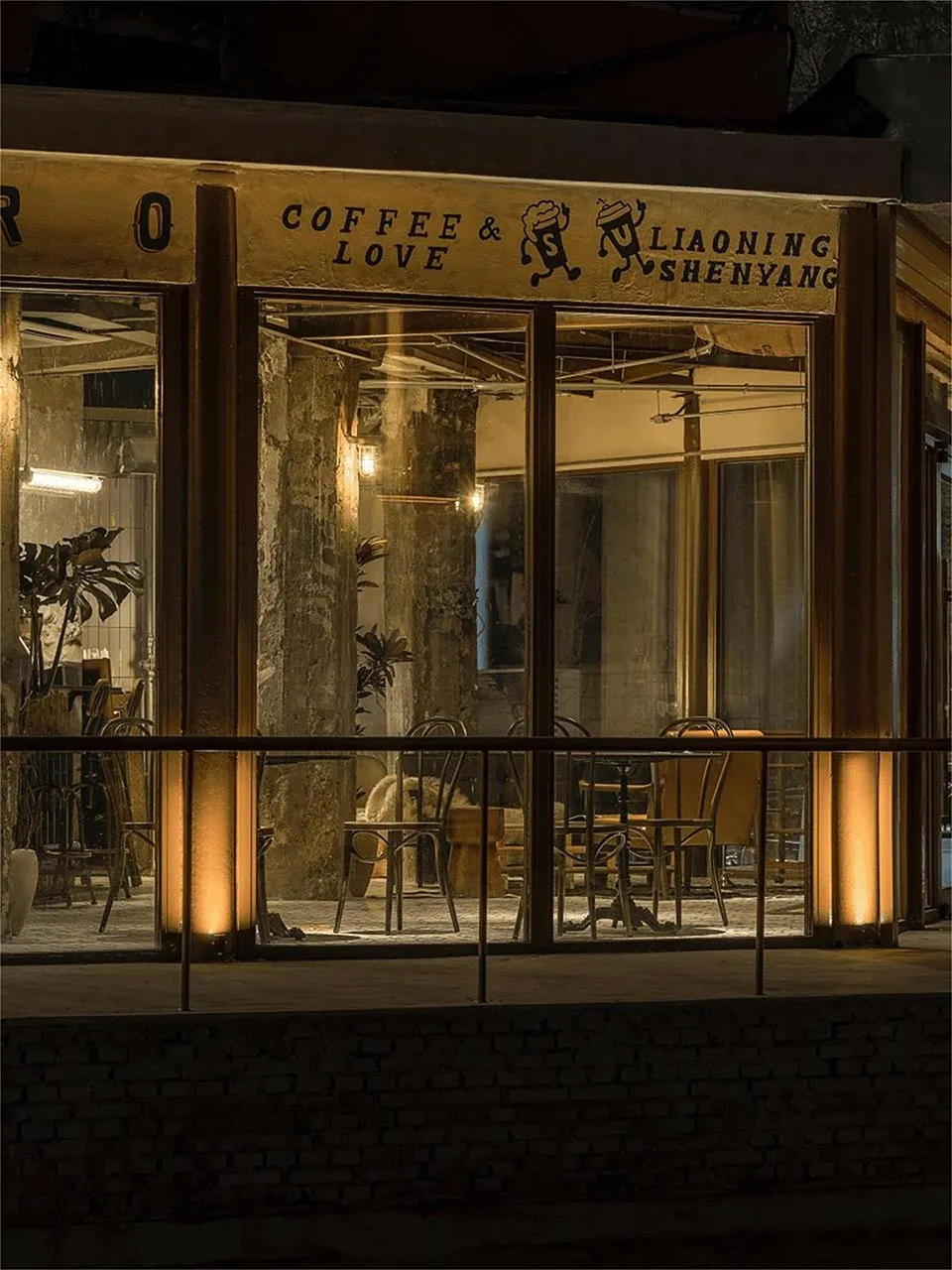 Cozy coffee shop with comfortable seating, artwork on the walls, and natural light from a large window