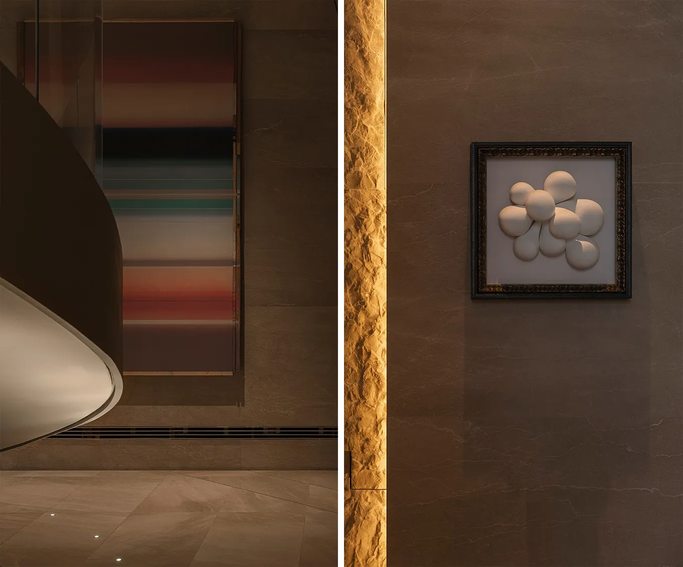 Elegant interior space with artwork, a clock, and a stone wall, featuring a mix of framed pictures and a painting