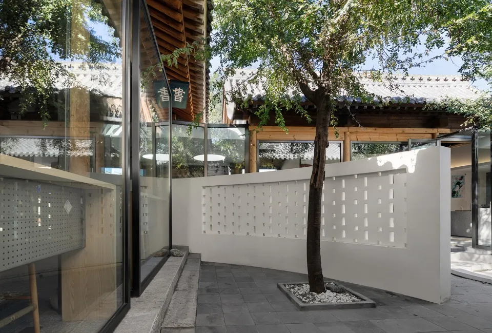 A building with white walls and a tree in front of it