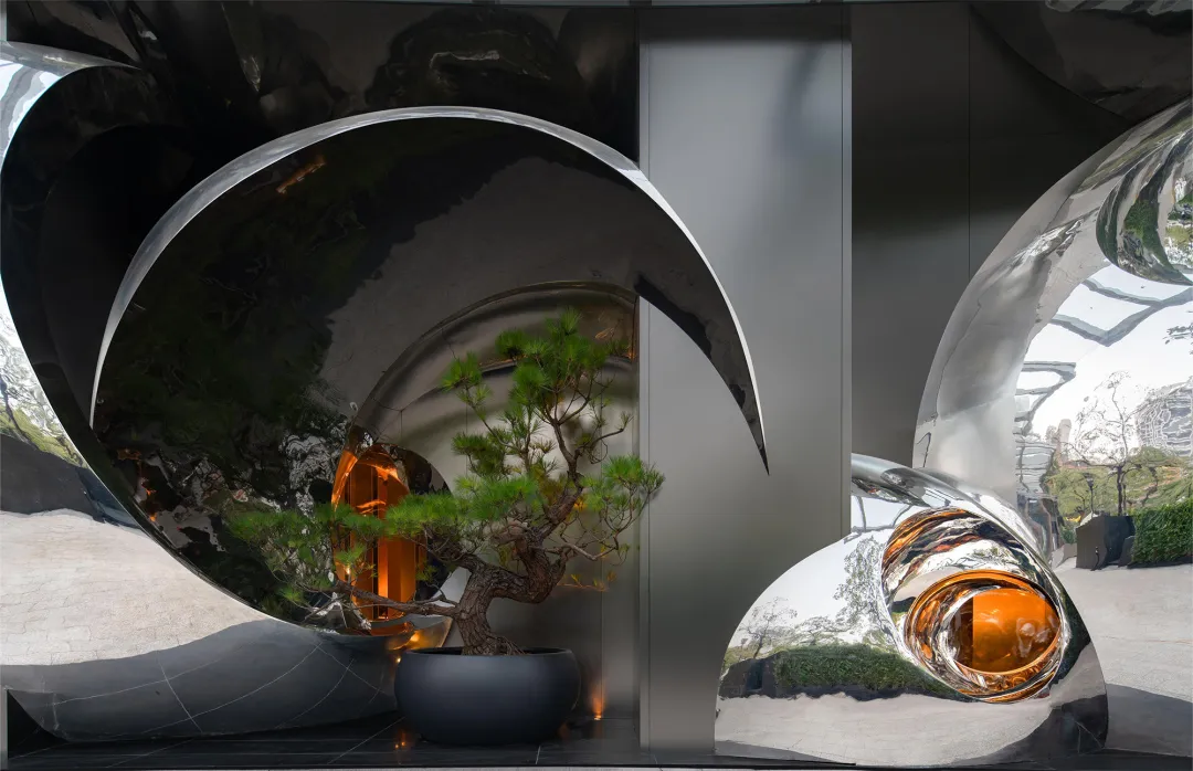 A modern living space with a glass sculpture featuring a small tree, clean lines, and reflective surfaces