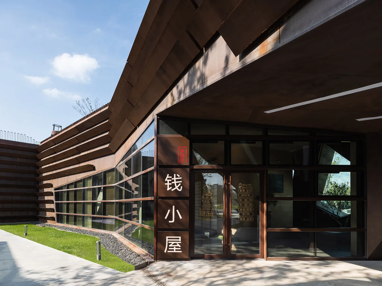亞洲風格建築，大型拱門入口、木質面板牆面，外頭自然光線灑入