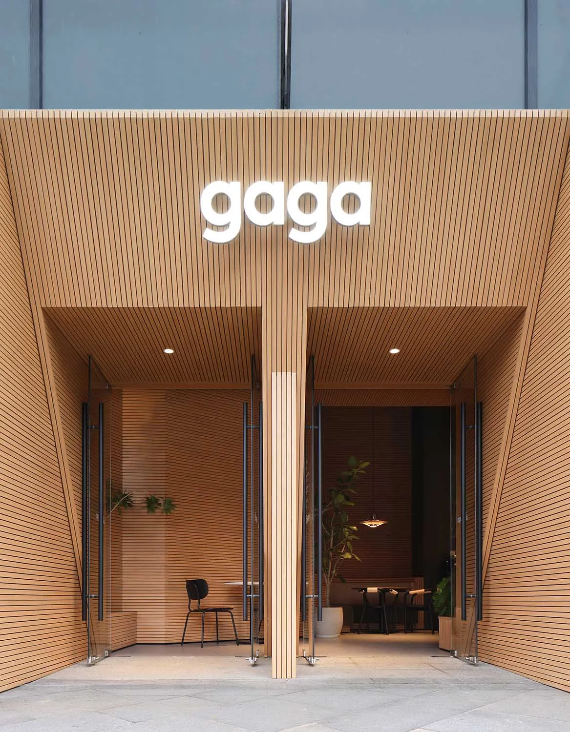 Warm and inviting entrance with wooden walls, doors, and potted plants adding a touch of greenery