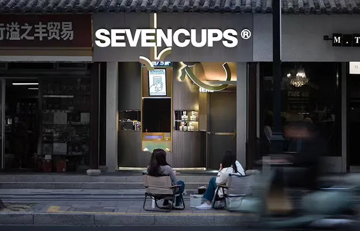 兩位女子在木質元素的溫馨亞洲餐廳戶外享用飲品