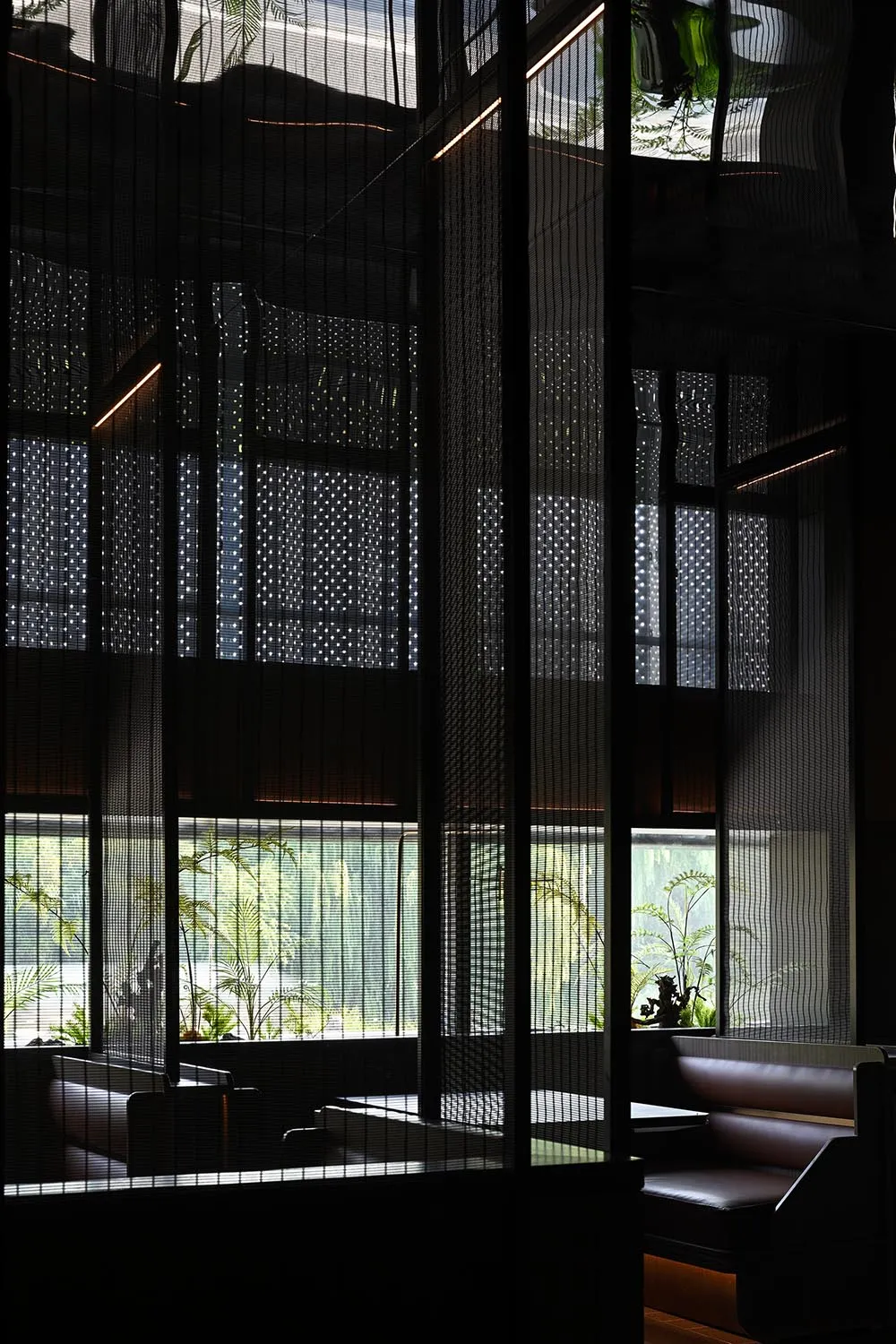現代餐廳黑色牆面用餐區，盆栽與極簡裝飾