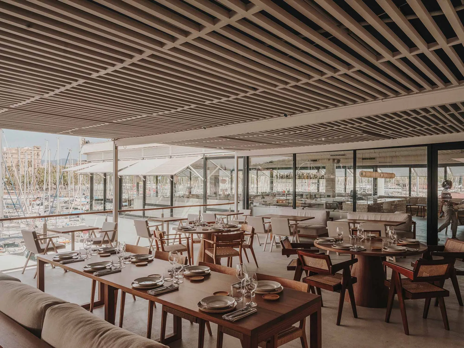 A modern restaurant interior with wooden tables and chairs, well-lit and inviting, with ample seating options