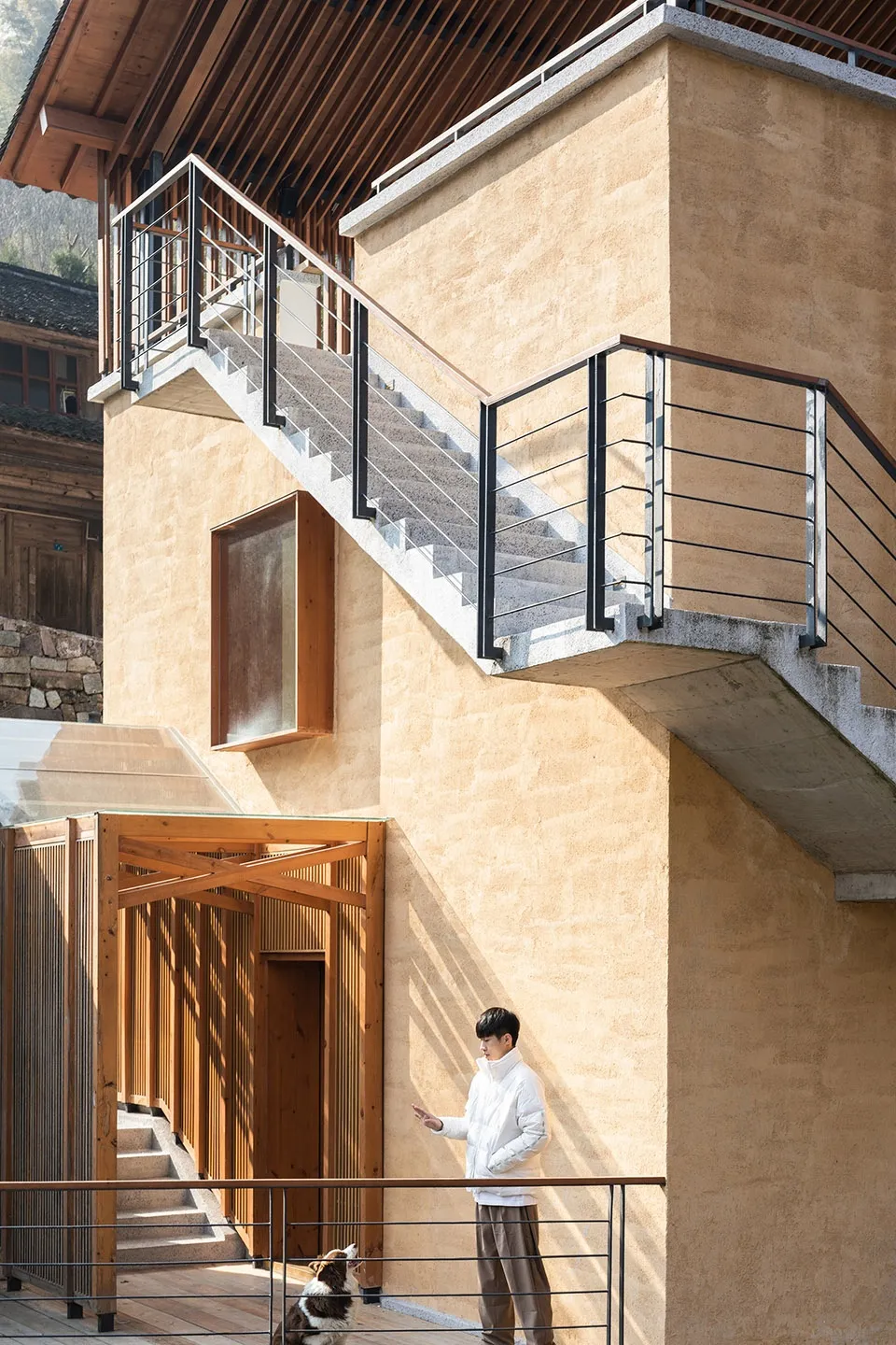 A rustic building with a wooden staircase, two people, and a traditional design