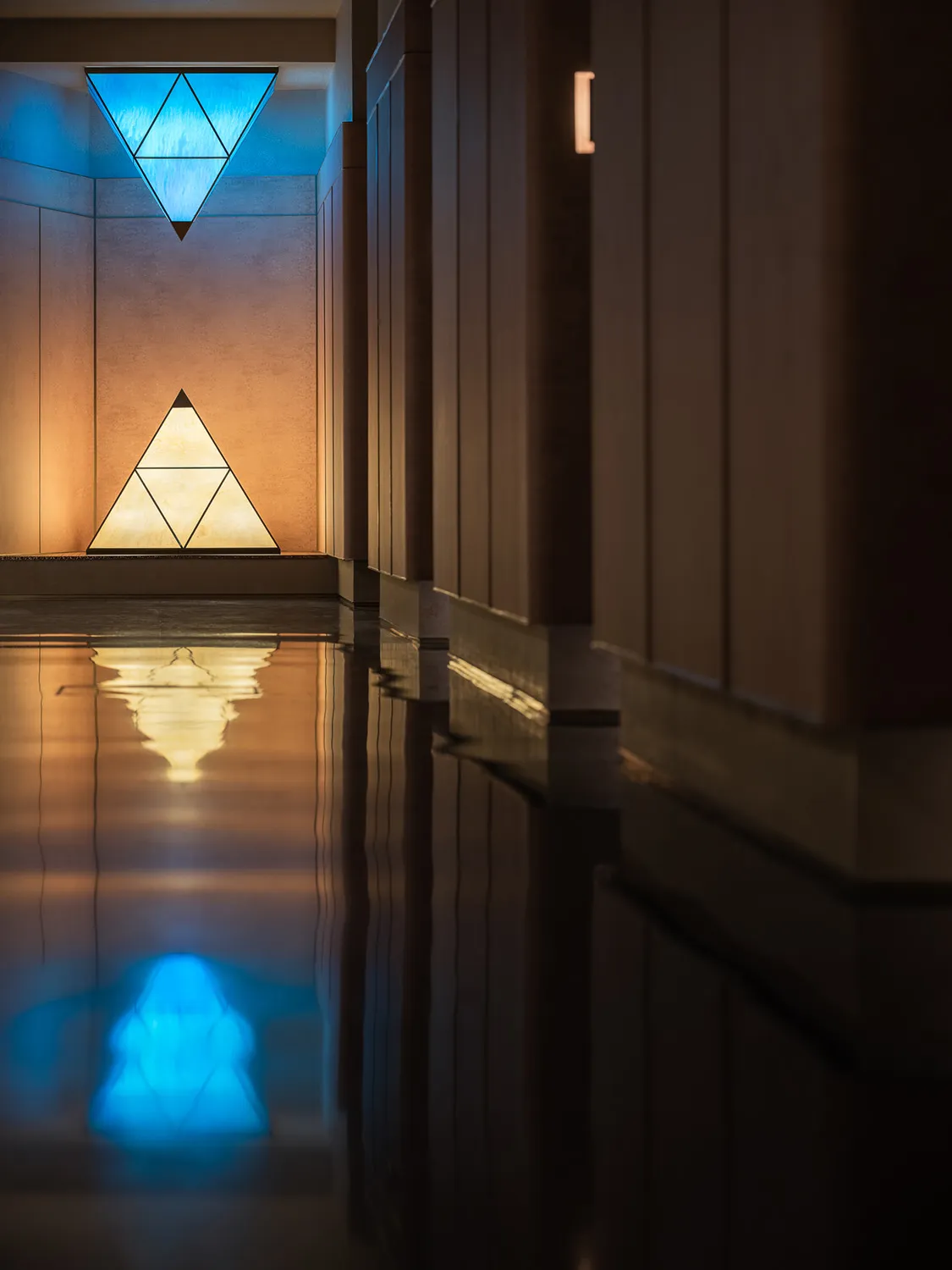 Wooden hallway with a large triangle shape, two lights, and a calm atmosphere