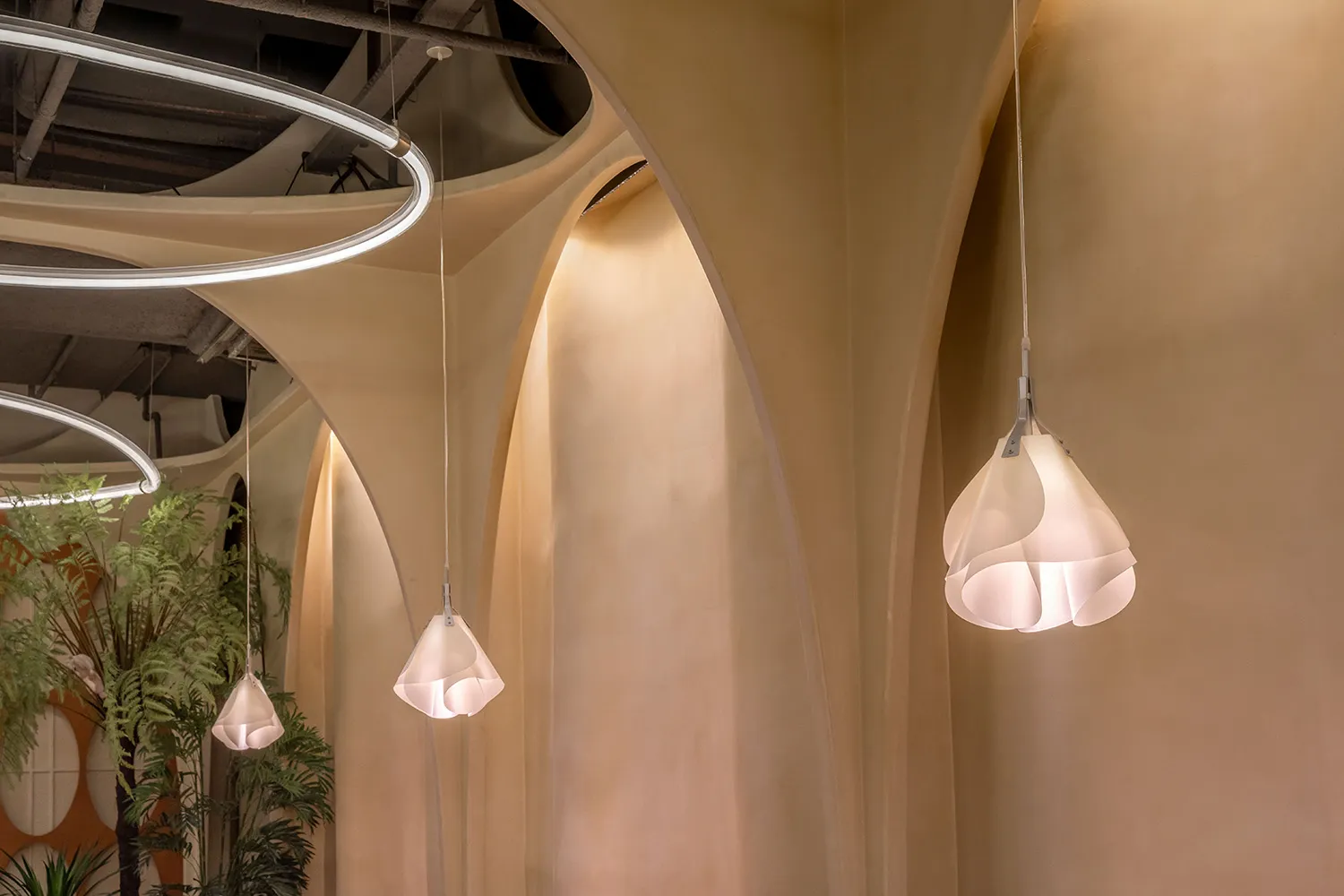 Large open space with high ceilings, arches, and stone walls, illuminated by hanging lights