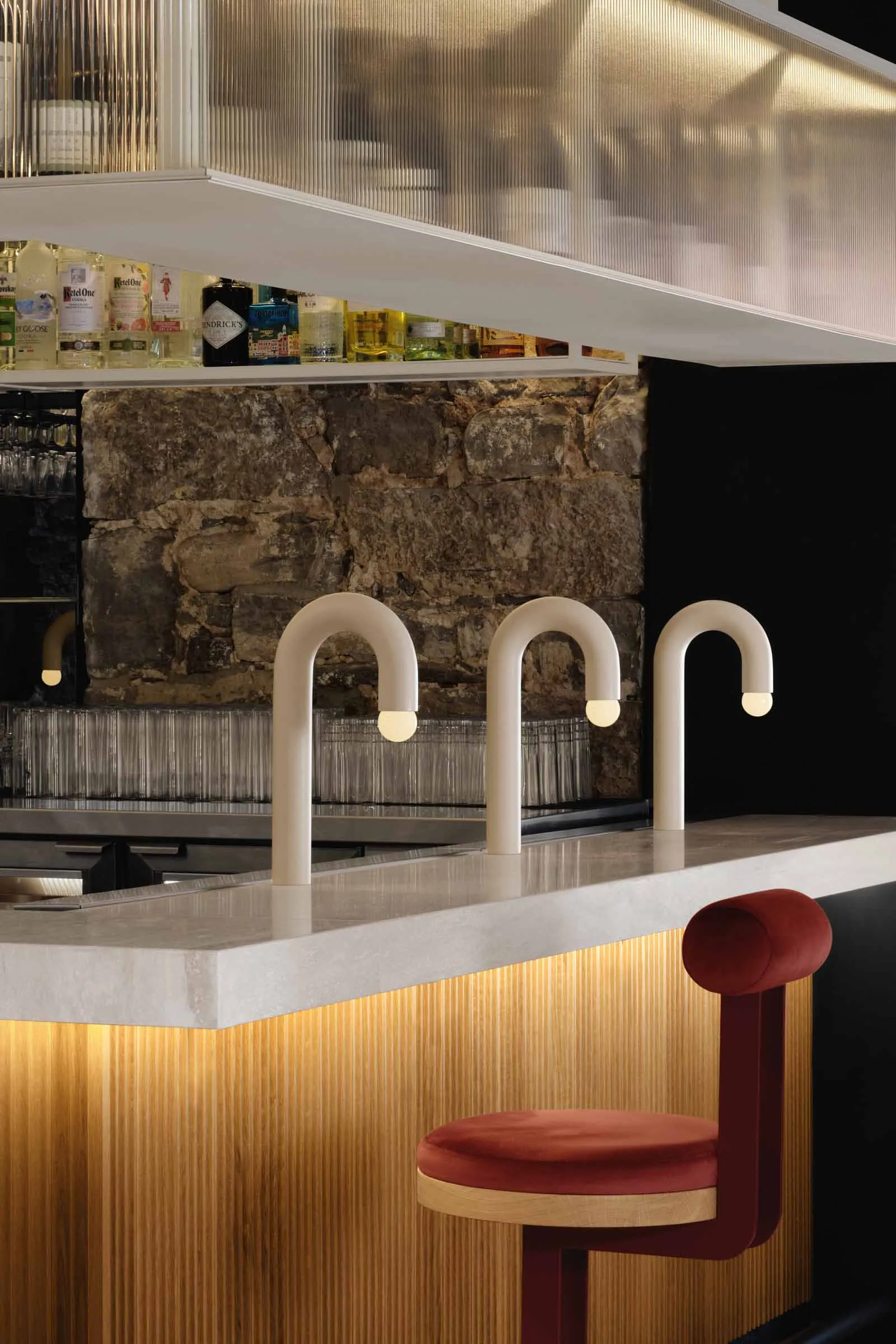 Modern kitchen with white faucets, wine glasses, and scattered cups on a countertop