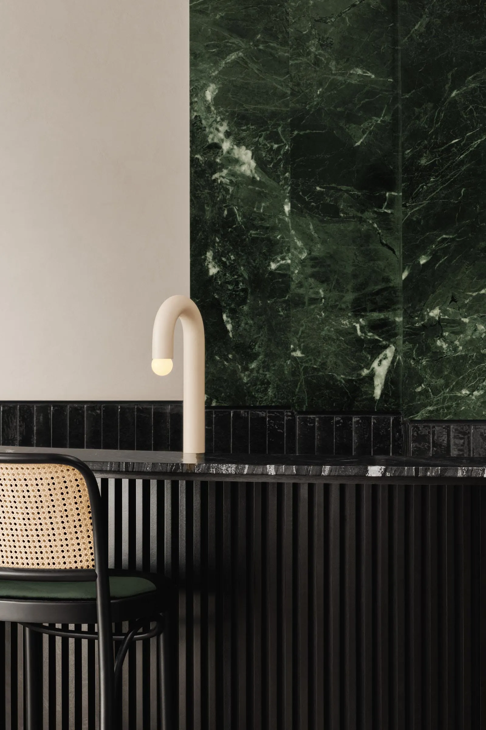 Modern bathroom with a black marble sink, two chairs, and a dining table, creating a luxurious atmosphere