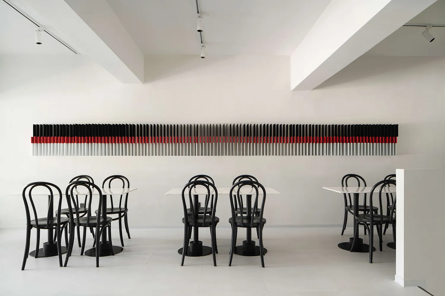 Formal dining area with multiple tables and chairs, utensils, and a well-organized atmosphere