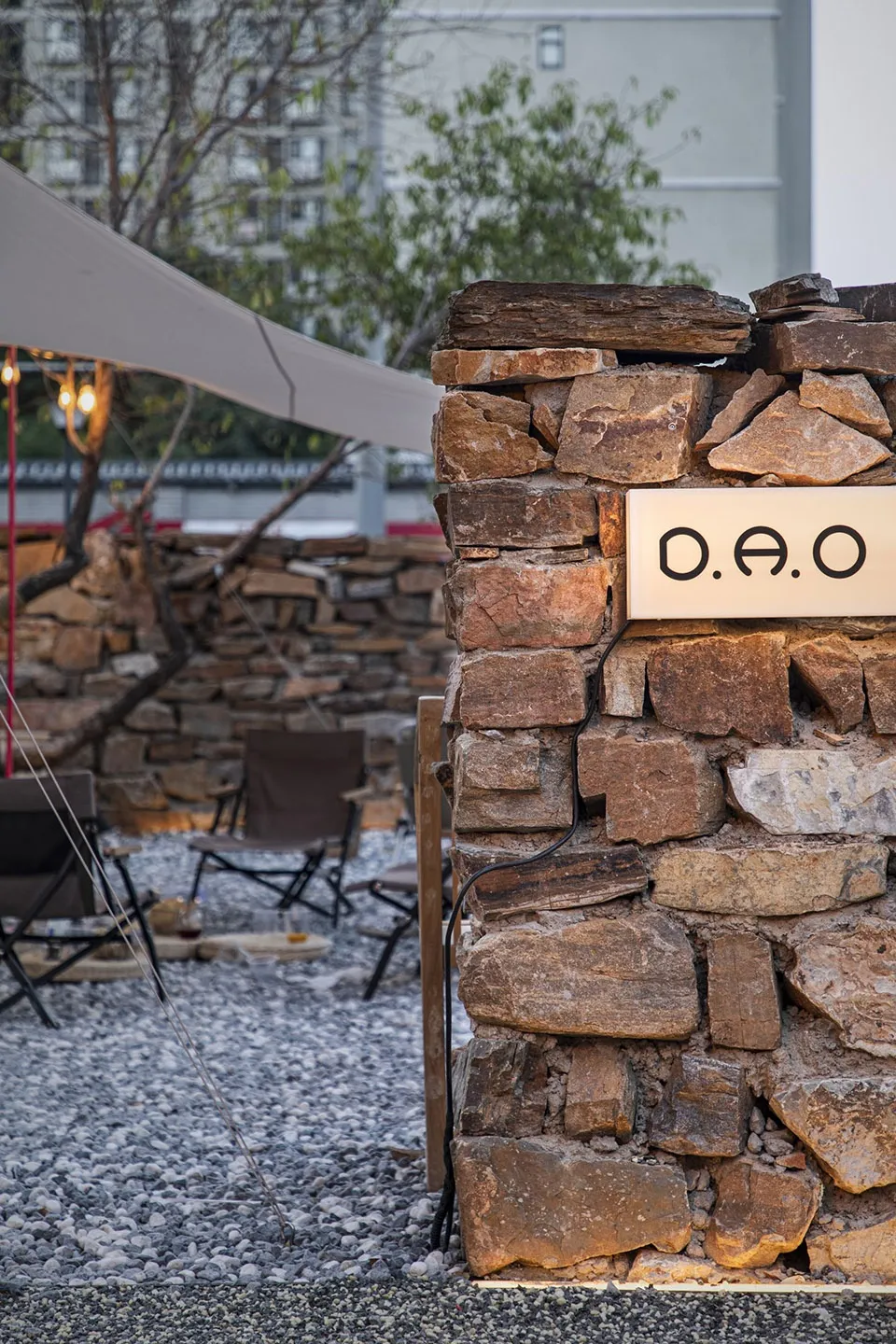 A casual outdoor seating area with several chairs and dining tables, surrounded by a relaxed atmosphere