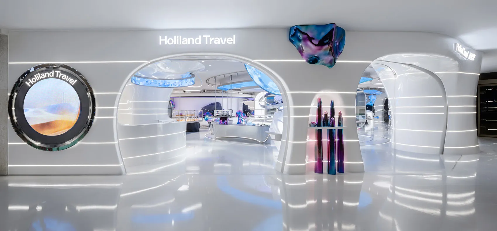 A large, modern hotel lobby with white walls, high ceilings, and several sculptures, featuring a minimalist and contemporary style