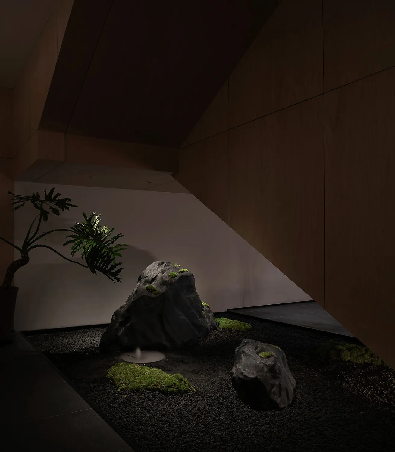 溫馨舒適的客廳空間，設有岩石庭園、盆栽與座椅，營造自然氛圍與柔和燈光