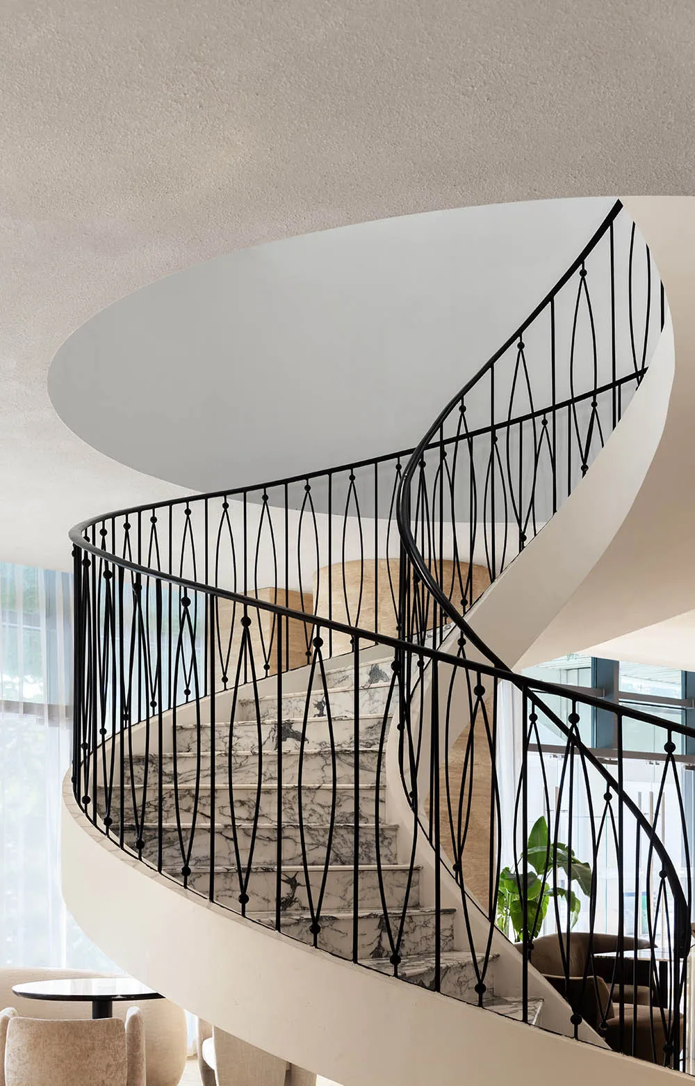 A real photo of a modern staircase with metal stairs, surrounded by walls with decorative elements and artwork, conveying a sense of elegance and luxury