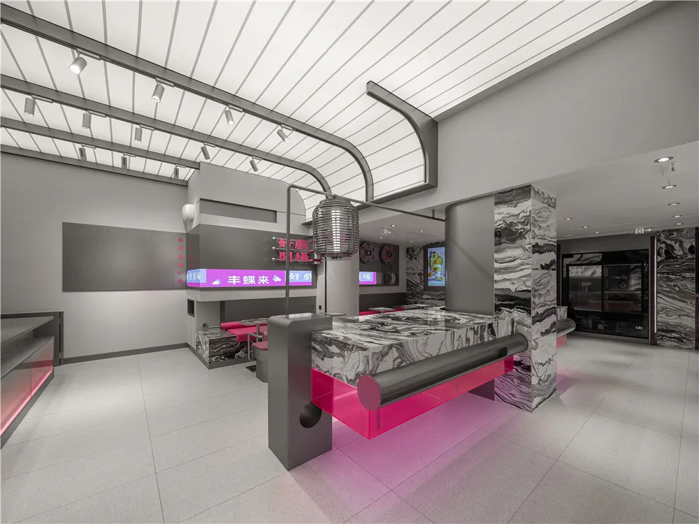 Modern hotel lobby with a pink and grey marble counter, chairs, and clean lines