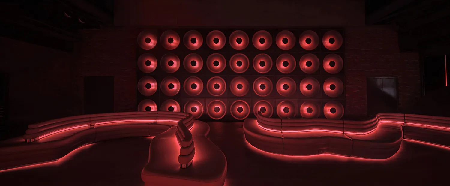 A modern living space with a large white leather couch in front of a wall covered in red lights, creating a warm and inviting atmosphere