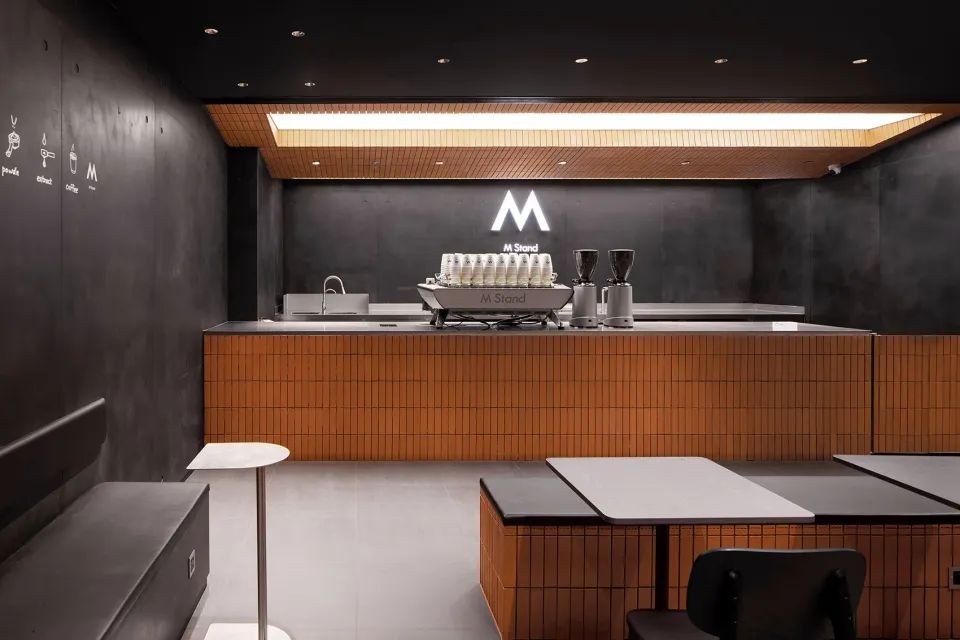 Industrial kitchen with a counter featuring two coffee machines and cups, clean and well-organized atmosphere