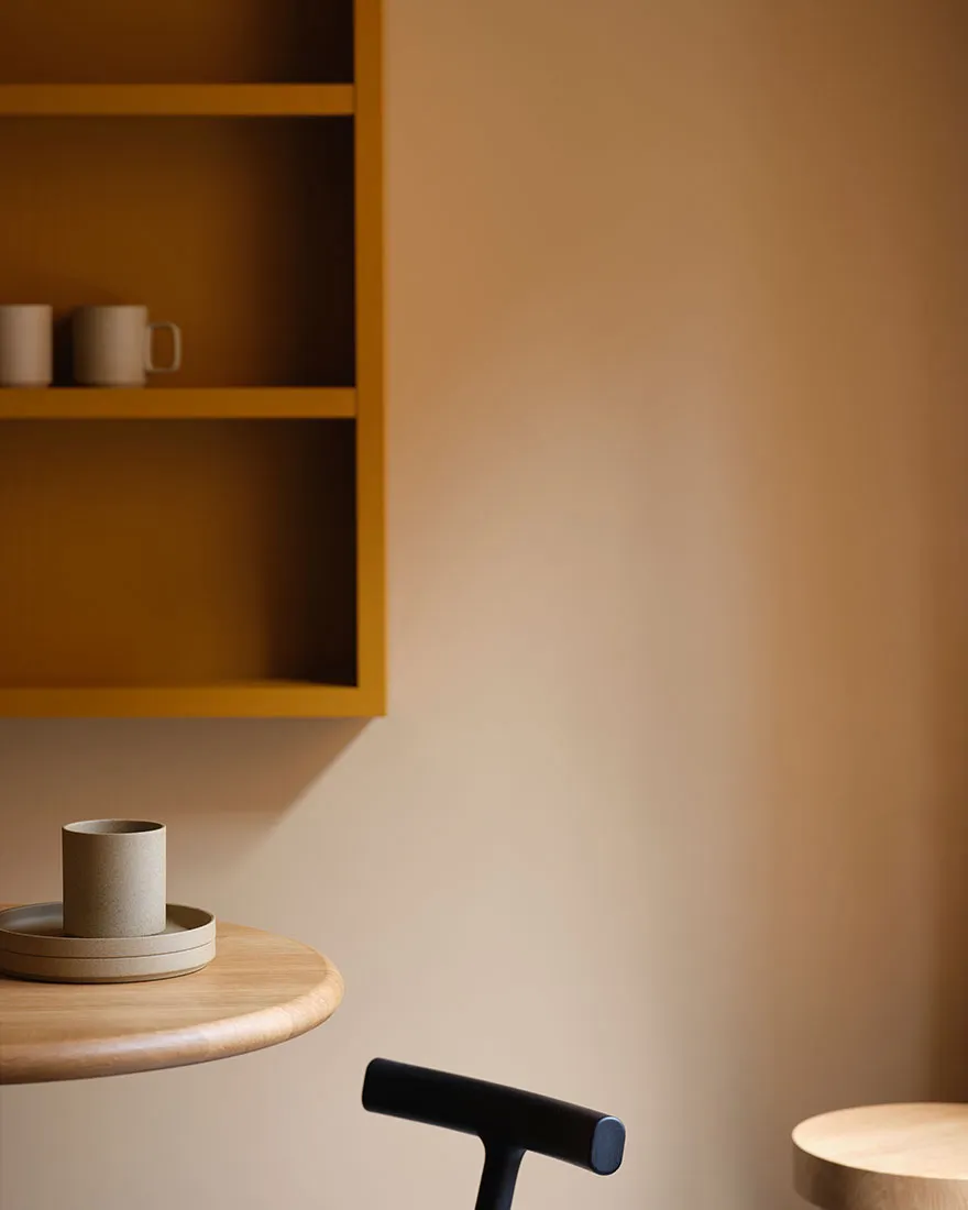A cozy living area with a wooden table featuring two cups and two bowls, surrounded by a warm and inviting atmosphere