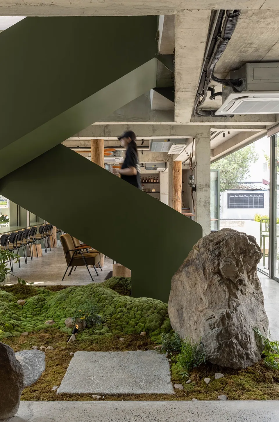 Inviting cafe with a staircase, chairs, and a potted plant, creating a comfortable atmosphere for guests